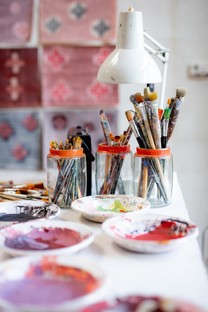 Assiette blanche avec pinceaux et peinture utilisée lors d'un atelier créatif pitchoun art pour enfants a hourtin dans le medoc