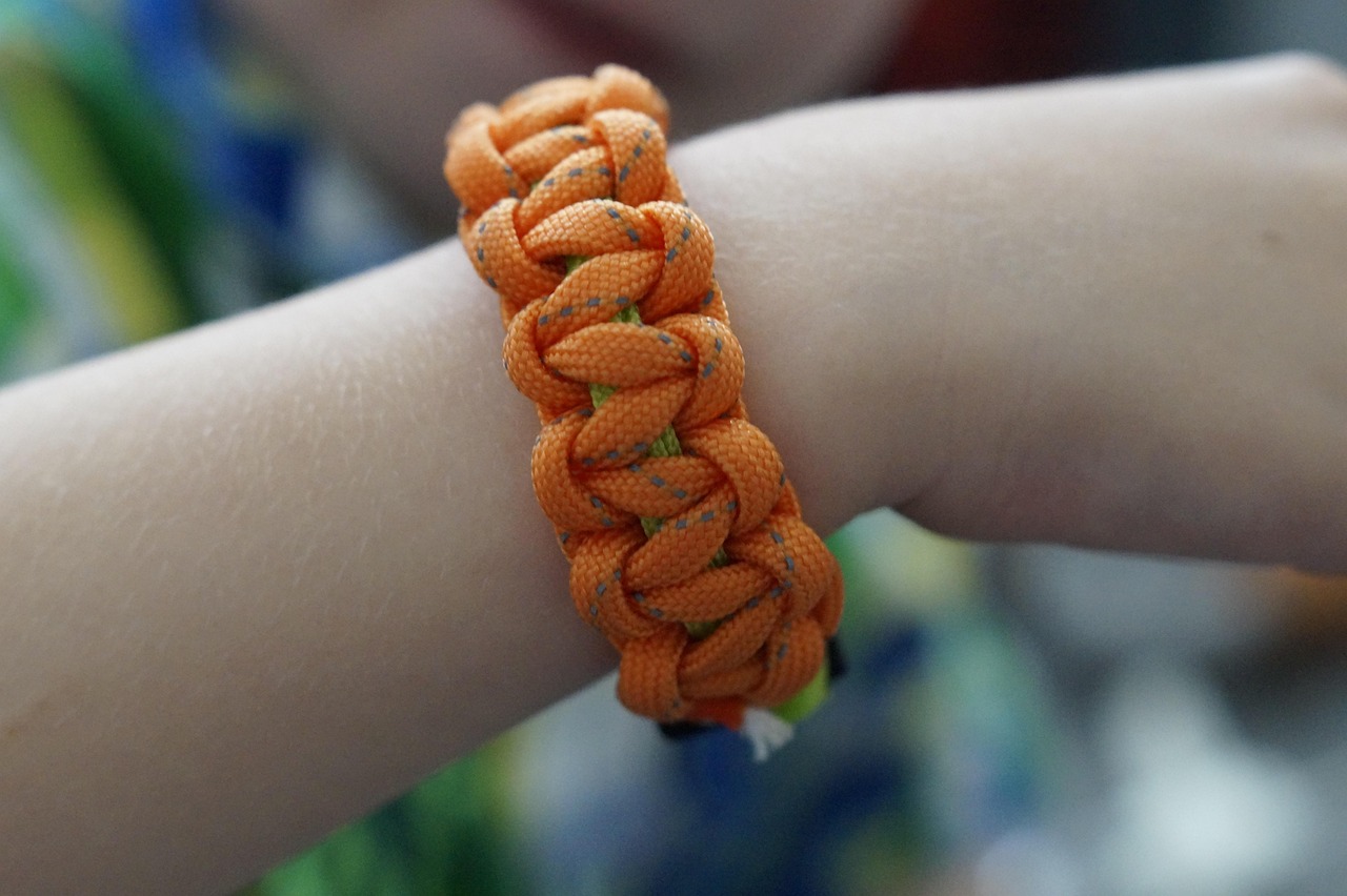 Bracelet de survie en paracorde réalisé et porté par un enfant lors d’un atelier DIY créatif à Hourtin